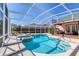 Inviting screened-in pool with a soothing spa and comfortable lounging area at 6172 Knotty Pine Ct, Port Orange, FL 32127