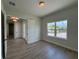 A bright, spacious bedroom with a large window overlooking lush greenery and neighborhood homes at 1010 Megano Blvd, Deland, FL 32724