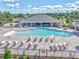 Resort-style pool featuring ample seating, a large clubhouse, and landscaped surroundings under a sunny sky at 1010 Megano Blvd, Deland, FL 32724