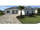 Beautiful single Gathering home with manicured lawn and charming front yard with a paver driveway and a palm tree at 1010 Megano Blvd, Deland, FL 32724
