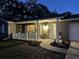 Charming home exterior featuring a cozy front porch, white railing, and beautifully landscaped flower beds at 1433 Mollie Rd, Daytona Beach, FL 32114