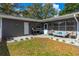 Cozy patio area with outdoor seating, grill, and white rock landscaping, perfect for relaxing and entertaining at 1433 Mollie Rd, Daytona Beach, FL 32114