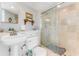 Well lit bathroom featuring a shower with a glass door and pedestal sink at 925 N Halifax Ave # 1105, Daytona Beach, FL 32118