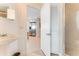 Bright bathroom with a pedestal sink, tiled floors, open to shower, and entry to stainless steel refrigerator at 925 N Halifax Ave # 1105, Daytona Beach, FL 32118