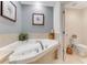 This bathroom features a jetted tub, a marble tiled backsplash and a plant at 925 N Halifax Ave # 1105, Daytona Beach, FL 32118