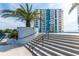 Low angle shot of exterior of a blue and white high-rise condo with palm trees at 925 N Halifax Ave # 1105, Daytona Beach, FL 32118