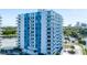 Aerial view of a condo building featuring balconies and a waterfront setting with lush greenery and ample parking at 925 N Halifax Ave # 1105, Daytona Beach, FL 32118