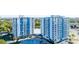 Exterior of twin condo towers, featuring balconies, shared pool, landscaping, and waterfront views at 925 N Halifax Ave # 1105, Daytona Beach, FL 32118