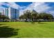 Large manicured lawn and mature trees with condo buildings in the background at 925 N Halifax Ave # 1105, Daytona Beach, FL 32118