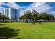 Lush green lawn in front of condominium buildings under a sunny sky, with parking lot nearby at 925 N Halifax Ave # 1105, Daytona Beach, FL 32118