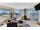 The living room features floor to ceiling windows, a black leather couch, and a fireplace at 925 N Halifax Ave # 1105, Daytona Beach, FL 32118