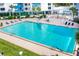 Outdoor swimming pool with lounge chairs and umbrellas with palm trees at 925 N Halifax Ave # 1105, Daytona Beach, FL 32118
