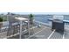 Bar height patio furniture with an outdoor grill on a rooftop patio. (Virtually Staged) at 925 N Halifax Ave # 1105, Daytona Beach, FL 32118