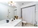 Bathroom with white vanity, mirror, toilet, and shower with curtain at 230 Katrina St # 230, De Leon Springs, FL 32130
