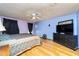 Bedroom features queen bed, TV on dresser, wood floors and a ceiling fan at 230 Katrina St # 230, De Leon Springs, FL 32130