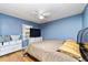 Bedroom with blue walls, wood floors, TV on dresser, and a ceiling fan at 230 Katrina St # 230, De Leon Springs, FL 32130