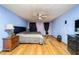 Bedroom featuring queen bed, wood floors, ceiling fan, dresser with TV, and a lamp on nightstand at 230 Katrina St # 230, De Leon Springs, FL 32130
