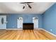 Living room featuring hardwood floors, blue accent wall, two windows and a TV at 230 Katrina St # 230, De Leon Springs, FL 32130
