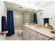 Well-lit bathroom featuring a vanity with sink and a shower-tub combo with blue curtain at 1 Tomoka Oaks Blvd # 102, Ormond Beach, FL 32174