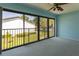 Bright bedroom with big sliding glass doors leading to a balcony and ceiling fan with light at 1 Tomoka Oaks Blvd # 102, Ormond Beach, FL 32174
