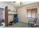 Bedroom view: Carpeted room with window, wood blinds, shelves, and ceiling fan with light at 1 Tomoka Oaks Blvd # 102, Ormond Beach, FL 32174