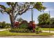 Community entrance sign featuring beautiful landscaping and mature trees at 1 Tomoka Oaks Blvd # 102, Ormond Beach, FL 32174