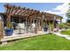 A backyard with a wooden pergola, green grass, and patio furniture, perfect for outdoor relaxation at 1060 Still Rd, Pierson, FL 32180