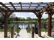 View of a backyard pool featuring a wooden pergola and view of surrounding greenery and fenced yard at 1060 Still Rd, Pierson, FL 32180