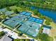 Aerial view of the tennis courts overlooking a beautiful lake at 1128 Hansberry Ct, Ormond Beach, FL 32174
