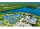 Overhead view of the tennis and pool club situated alongside a lake and surrounded by lush greenery at 1128 Hansberry Ct, Ormond Beach, FL 32174