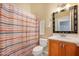 Bathroom features vanity with wooden cabinet and striped shower curtain at 1128 Hansberry Ct, Ormond Beach, FL 32174