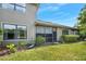 Rear exterior view highlighting the screened lanai and well-maintained landscaping at 1128 Hansberry Ct, Ormond Beach, FL 32174
