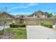 Charming home showcasing a three-car garage and manicured landscaping at 1128 Hansberry Ct, Ormond Beach, FL 32174