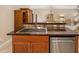 Kitchen island with a stainless steel dishwasher, sink and wood cabinets at 1128 Hansberry Ct, Ormond Beach, FL 32174