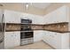 Bright kitchen with white cabinets, modern stainless steel appliances, and tile backsplash at 1128 Hansberry Ct, Ormond Beach, FL 32174