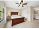 Comfortable main bedroom featuring a ceiling fan, plush carpet, and an ensuite bathroom at 1128 Hansberry Ct, Ormond Beach, FL 32174