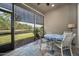 Enclosed patio with tiled floor, ceiling fan, table, and view of the lake at 1128 Hansberry Ct, Ormond Beach, FL 32174