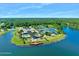 Aerial view showcases tennis courts, a resort-style pool, and clubhouse amenities nestled by a serene lake at 1128 Hansberry Ct, Ormond Beach, FL 32174