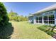 Spacious backyard with lush green grass and views of the home's exterior windows at 1404 Newry Cir, Ormond Beach, FL 32174