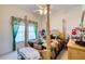 Comfortable bedroom featuring a four-poster bed, ceiling fan, and window with decorative floral valance at 1404 Newry Cir, Ormond Beach, FL 32174