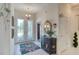 Bright foyer with a decorative cabinet, tile flooring, and patterned front doors at 1404 Newry Cir, Ormond Beach, FL 32174
