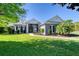 Beautifully landscaped front yard with mature tree and manicured lawn leading to this elegant home at 1404 Newry Cir, Ormond Beach, FL 32174