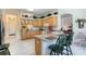Bright kitchen featuring light wood cabinetry, bar seating, and stainless steel appliances at 1404 Newry Cir, Ormond Beach, FL 32174