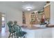 Well-lit kitchen featuring a breakfast bar, cabinetry, and a stainless steel refrigerator at 1404 Newry Cir, Ormond Beach, FL 32174