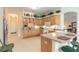 Bright kitchen featuring light wood cabinetry, bar seating, and stainless steel appliances at 1404 Newry Cir, Ormond Beach, FL 32174