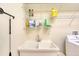 Laundry room featuring a utility sink, washer, dryer, and wire shelving at 1404 Newry Cir, Ormond Beach, FL 32174