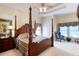 Bedroom featuring a four-poster bed, tray ceiling, and ample natural light at 1404 Newry Cir, Ormond Beach, FL 32174
