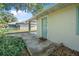 Charming back entrance with a light green door and a welcome mat on a concrete patio at 2120 Queen Palm Dr, Edgewater, FL 32141