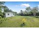 Expansive backyard, with lush green grass and mature trees, offering ample space for outdoor activities at 2120 Queen Palm Dr, Edgewater, FL 32141