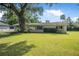 Well-maintained single-story home with tidy landscaping and a spacious green lawn at 2120 Queen Palm Dr, Edgewater, FL 32141